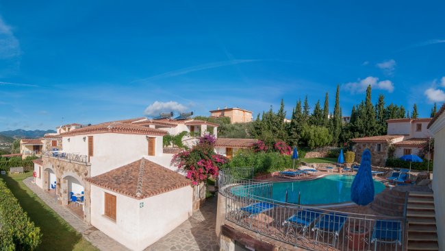 Edifici bianchi con tetti rossi e piscina.