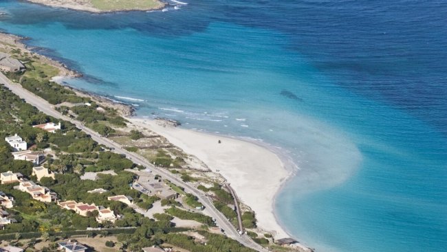 Spiaggia sabbiosa, mare turchese visto dall'alto.