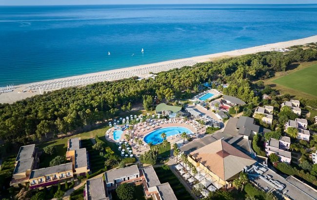 Vista aerea di un resort con piscina e spiaggia.