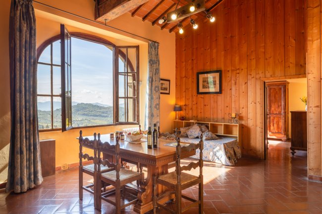 Sala da pranzo con tavolo e ampia finestra panoramica.