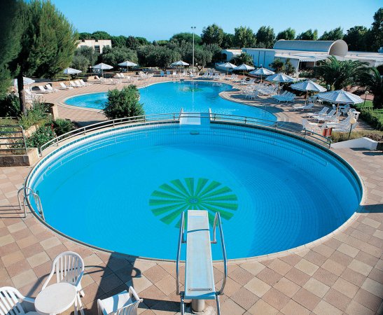 Piscine all'aperto con sdraio e ombrelloni.