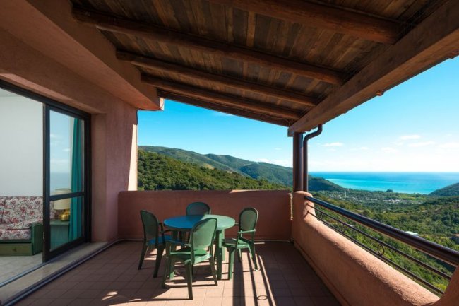 Terrazza coperta con tavolo e vista mare.