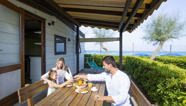 Famiglia colazione all'aperto davanti al mare.