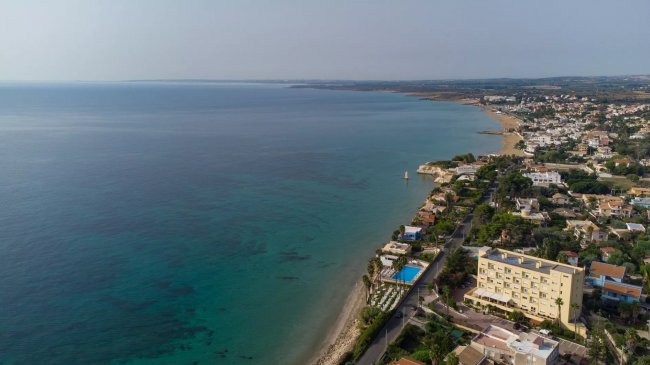Lungo costa con hotel, piscina e mare.