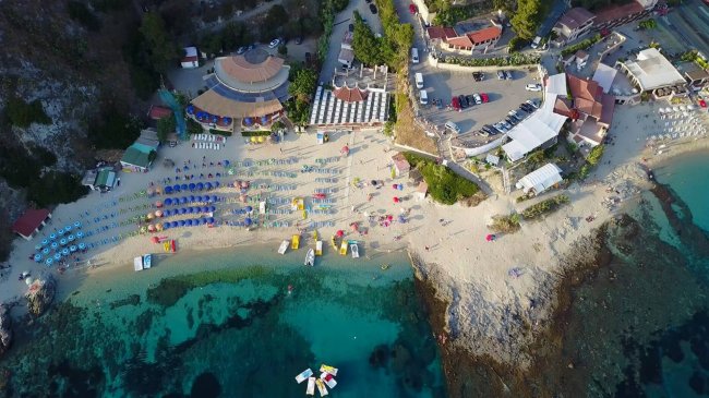 Spiaggia affollata con ombrelloni colorati.