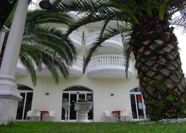 Edificio con balconi ed alte palme.