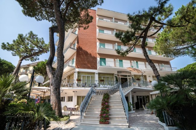 Edificio alberghiero con grande scala e alberi.
