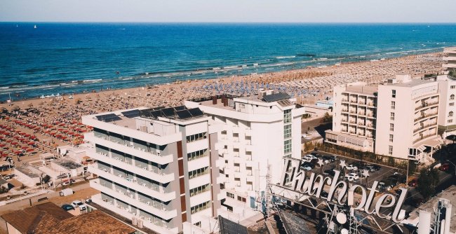 Vista aerea di hotel vicino a una spiaggia affollata.