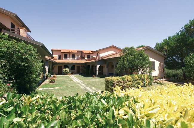 Complesso residenziale con prato e siepi.