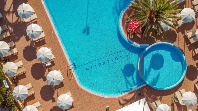 Piscina circondata da ombrelloni bianchi.