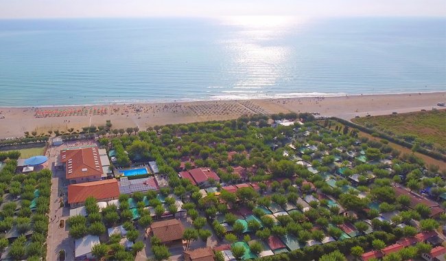 Vista aerea di un campeggio con piscina vicino alla spiaggia.