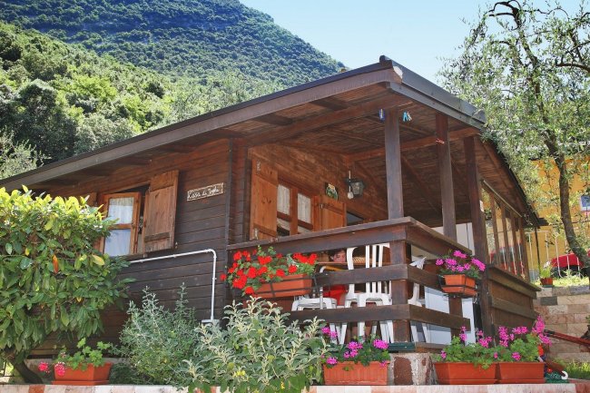 Chalet in legno con veranda e fiori decorativi.