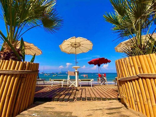 Palmette e ombrelloni su una spiaggia tropicale.