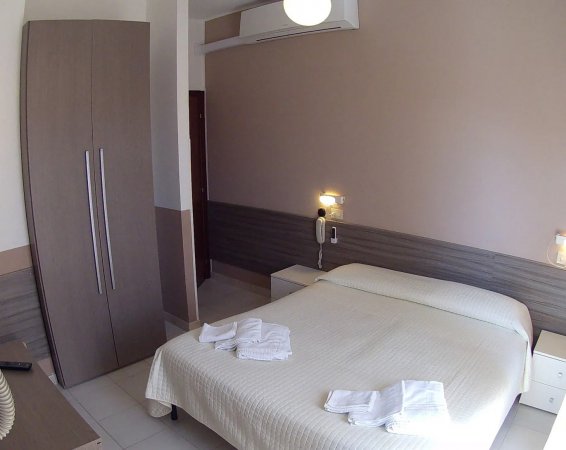 Camera con letto matrimoniale, armadio e asciugamani.