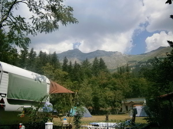 Camper e tende in un campeggio montano.