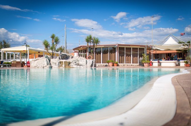 Piscina con rocce decorative e piante attorno.