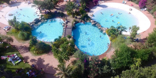 Tre piscine circondate da vegetazione.