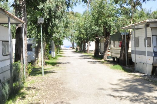 Sentiero tra roulotte e alberi.
