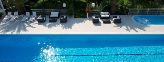 Piscina all'aperto con sedie a sdraio.