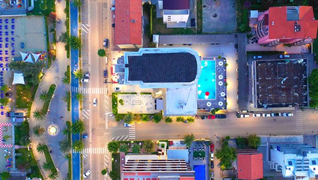 Vista dall'alto di un edificio con piscina e strade illuminate.