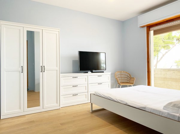 Camera moderna con letto, armadio e TV.