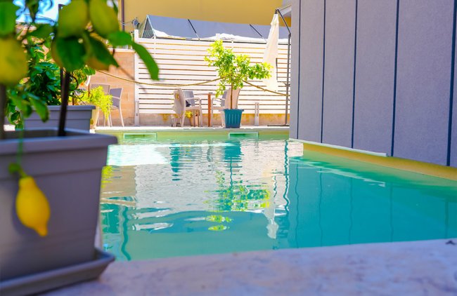 Piscina riflettente e pianta di limoni in un ambiente esterno rilassante.