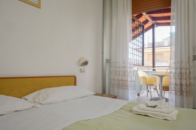 Camera con letto matrimoniale e balcone.