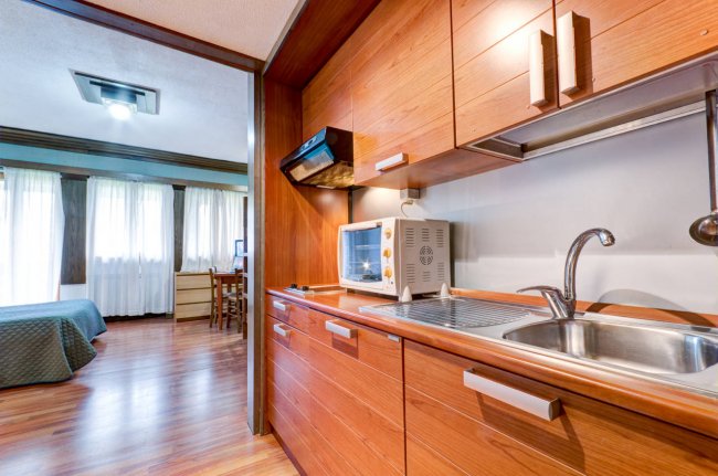 Angolo cucina moderno con lavello e forno, vista sulla camera.