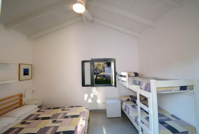 Stanza con soffitto alto e letti a castello.