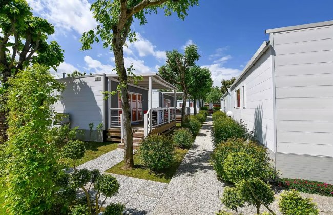 Casette moderne lungo un vialetto alberato.