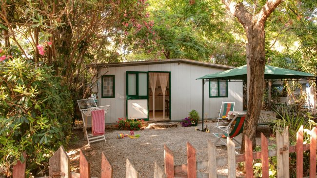 Casetta con giardino, tavolo e sedie.