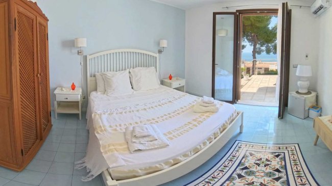 Camera da letto luminosa con vista sul mare.