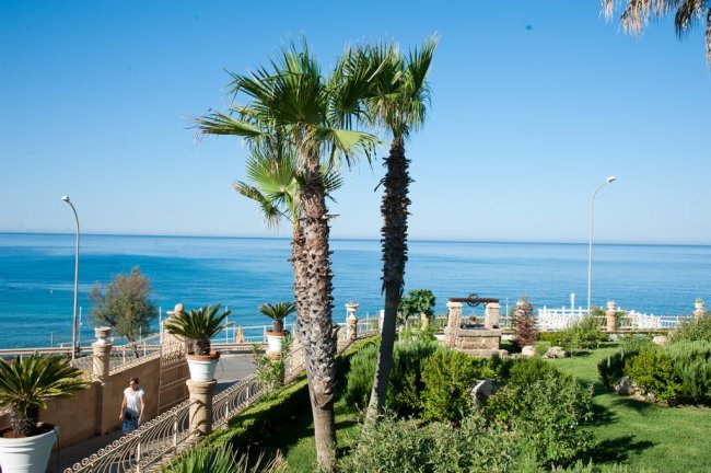 Giardino con palme e vista mare.