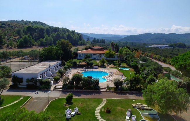 Vista aerea di un complesso con piscina e giardini.