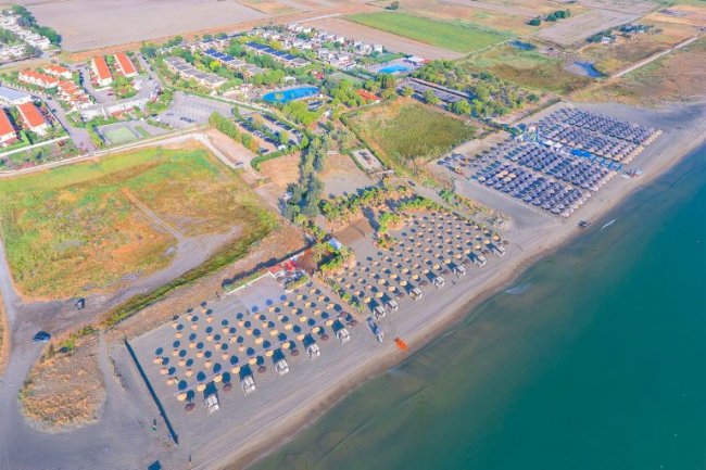Foto aerea di spiaggia con ombrelloni.