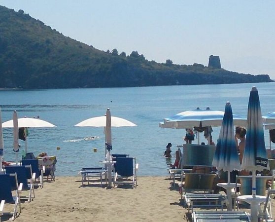 Spiaggia con lettini, ombrelloni e vista mare.