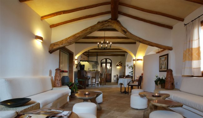 Salotto rustico con travi in legno a vista.