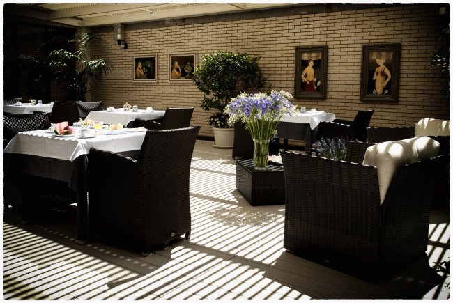 Terrazza con tavoli, sedie e piante.