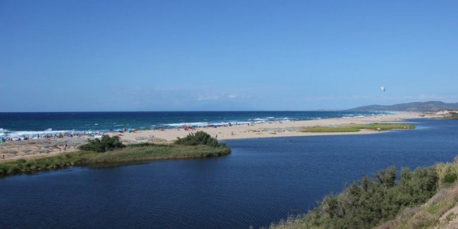 Un fiume si incontra col mare su una spiaggia.