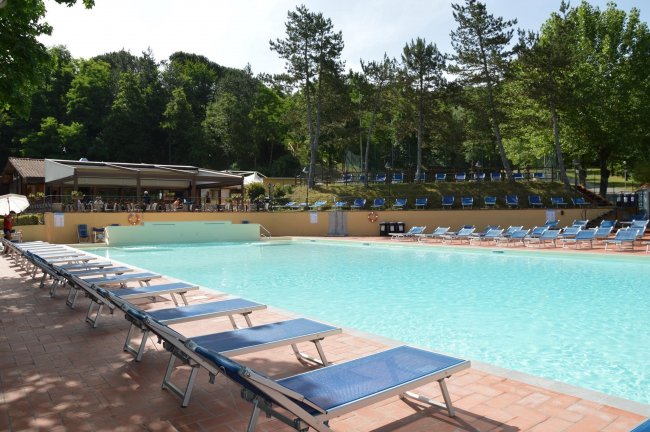 Piscina con lettini azzurri attorno.