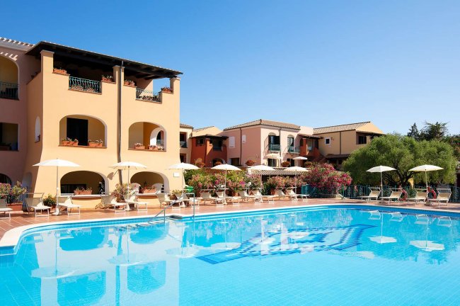 Piscina grande contornata da edifici colorati.