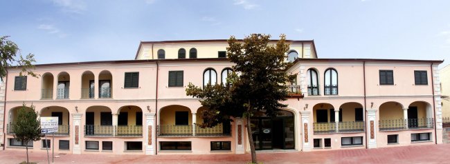 Ampia facciata di edificio con archi e balconi.