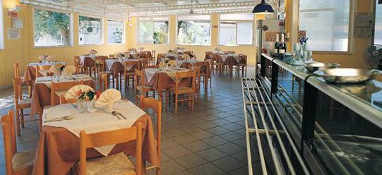 Una sala da pranzo luminosa con tavoli apparecchiati.