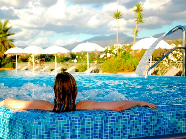 Persona rilassata in piscina con vista panoramica.