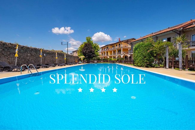 Piscina all'aperto con ombrelloni gialli.