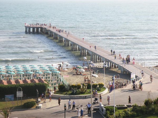 Molo affollato che si estende sul mare.