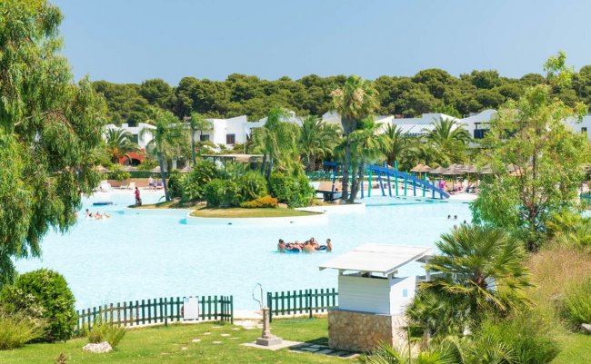 Piscina con isola verde e scivolo blu.