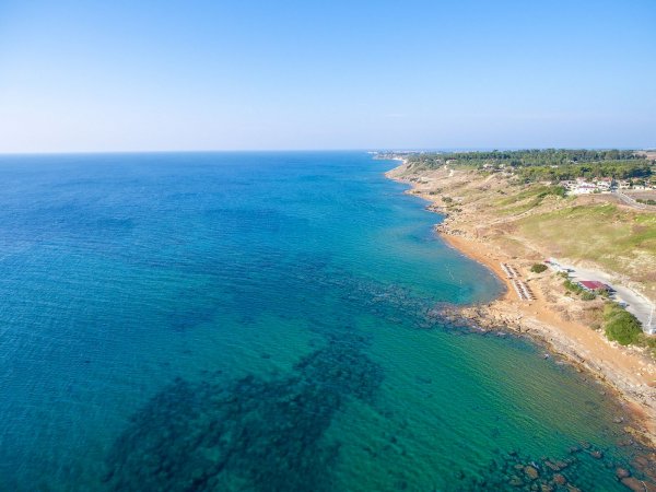 Costa rocciosa che si affaccia su un mare blu.