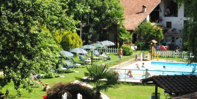 Piscina all'aperto con sdraio e ombrelloni.