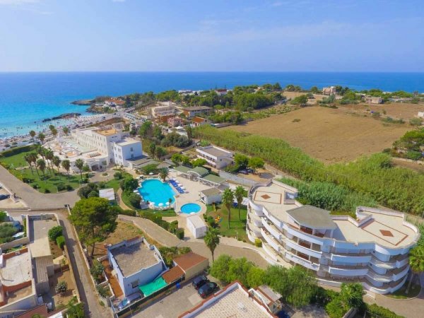Complesso residenziale con piscine e vista mare dall'alto.